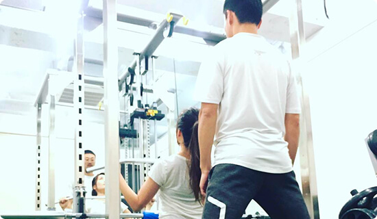 トレーナーとトレーニングをしている女性